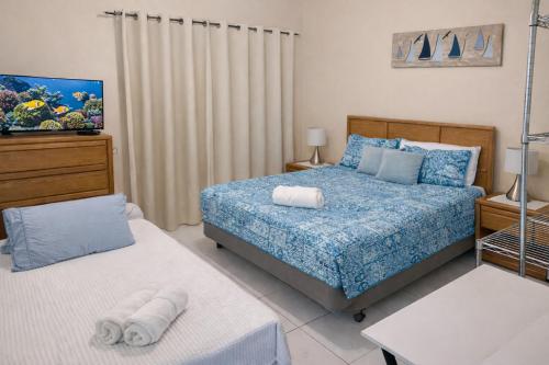 西湾SUITE 4, BLUE PAVILION - Steps to BEACH的卧室里有一张床和一台电视机