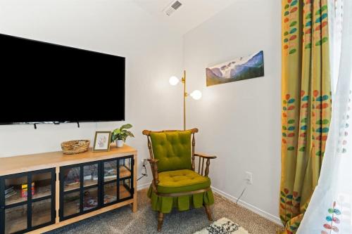 a living room with a television and a green chair at Caldwell Ruby Tuesday! 60's Inspired comfort 3B2B in Caldwell