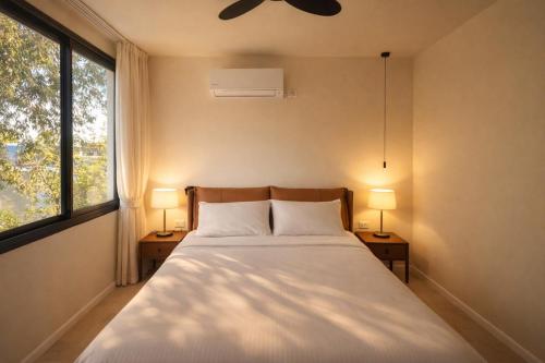una camera da letto con un letto con due lampade e una finestra di Luxury point a Giv‘atayim