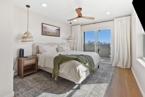 a white bedroom with a bed and a window at Caldwell Cliff Swallow Guest House in Caldwell