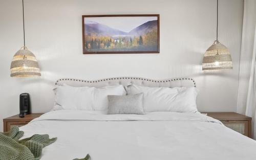 a bedroom with a white bed and two pendant lights at Caldwell Cliff Swallow Guest House in Caldwell