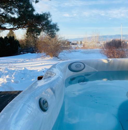 a tub covered in snow in a yard at Évasion sur l'Isle - spa in L'Isle-aux-Coudres