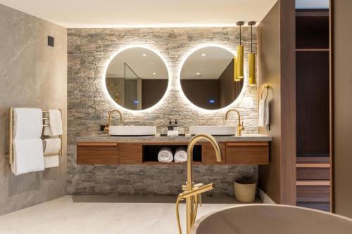 a bathroom with two sinks and two mirrors at Coronet Ridge Resort in Queenstown
