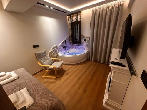 een badkamer met een bad en een tv en een bank bij Aje Villas 1959 in Ligiades
