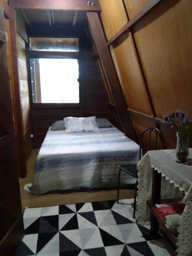 een slaapkamer met een bed en een geruite vloer bij Chalé Garças in Chapada dos Guimarães