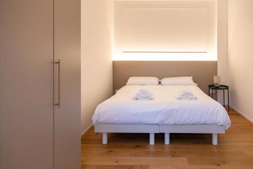 een slaapkamer met een wit bed met een raam bij Ca' Borsa IV - Suite con balcone in pieno centro in Treviso