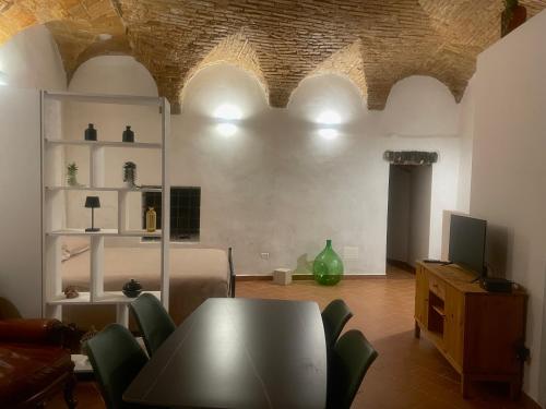 a living room with a table and chairs and a television at Casa "La Fonte" in Spoleto