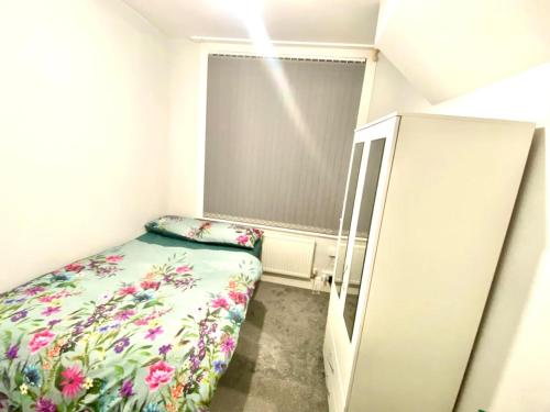 een kleine kamer met een bed en een raam bij OA Housing - Spacious 2 Bedrooms in Spon End