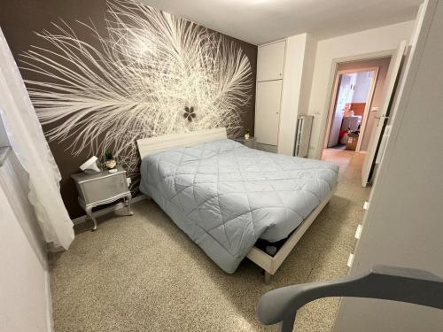 een slaapkamer met een bed met een schilderij aan de muur bij ARIEL'S house in San Benedetto del Tronto