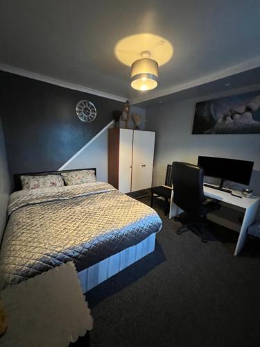 una camera da letto con un letto, una scrivania e un computer di room near Luton center a Luton