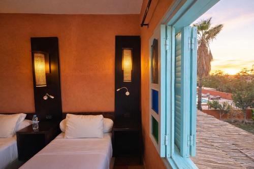 Zimmer mit 2 Betten und offenem Fenster in der Unterkunft Gite Souss in Oulad Teïma