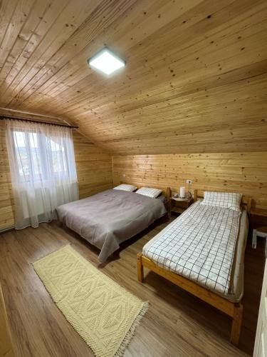 una camera con due letti in una baita di legno di Casa Diana a Huedin