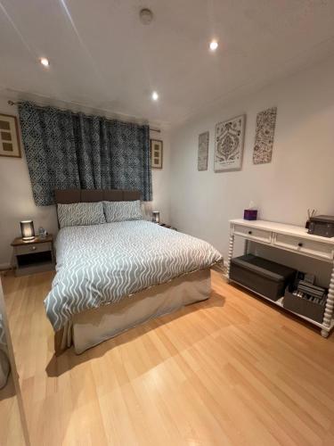 a bedroom with a large bed and a piano at The Bungalow by SJP - Double Room in Northamtonshire