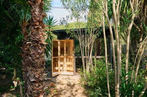 una porta in mezzo a un giardino alberato di Can Pardis a Cala Llonga