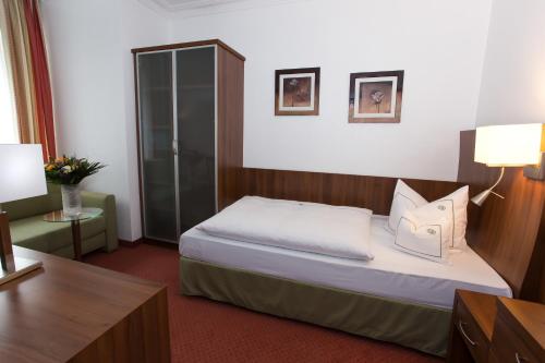 a hotel room with a bed and a desk at Hotel Coellner Hof in Cologne