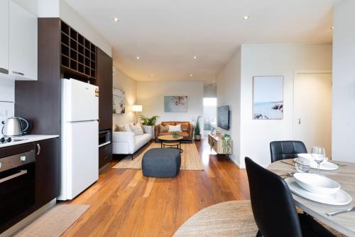 Una cocina y una sala con una mesa y un comedor. en Moments to Sand on Bear, en Mordialloc