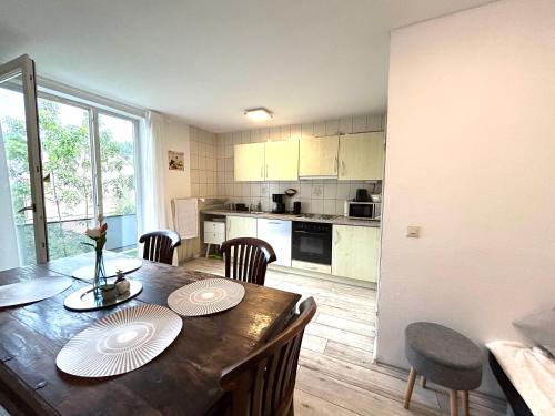 a kitchen and dining room with a wooden table and chairs at Apartment AlbGlück 1 Hechingen, 2 Schlafzimmer, bis 5 Personen, Burg 5 km in Hechingen