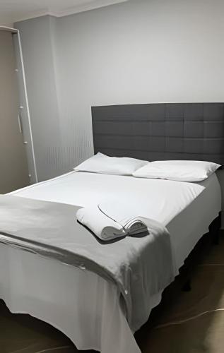 a white bed with a bow on top of it at Apto elegante no Catolé 63 in Campina Grande