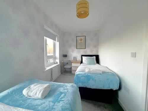 a bedroom with two beds and a window at Ashford Home off M20 with 2x Private Parking - Long Stays in Kent