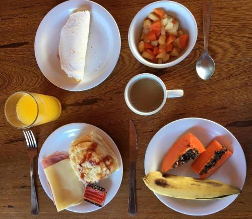 een tafel met borden ontbijtproducten en een kopje koffie bij Maraga Bento in Maragogi