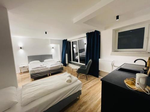 a hotel room with two beds and a desk at Milano Apartment in Hamburg