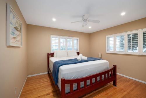 ein Schlafzimmer mit einem Bett und zwei Fenstern in der Unterkunft Pool Oasis Central Villa in Grossmont