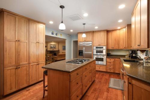 eine große Küche mit Holzschränken und einer Arbeitsplatte in der Unterkunft Pool Oasis Central Villa in Grossmont