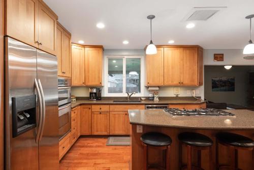 a kitchen with wooden cabinets and a stainless steel refrigerator at Pool Oasis Central Villa in El Cajon
