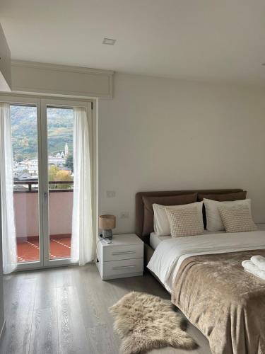 une chambre avec un lit et une grande fenêtre dans l'établissement Bernina View, à Tirano