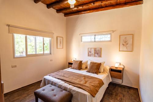 ein Schlafzimmer mit einem großen Bett und zwei Fenstern in der Unterkunft Kinien Suites de Montaña in Las Calles