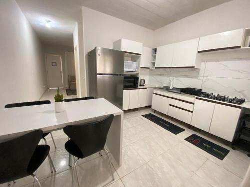 een keuken met witte kasten en een roestvrijstalen koelkast bij Sobrado Colinas in Balneário Camboriú