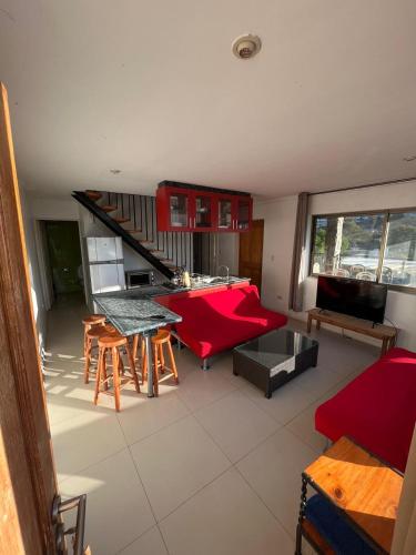 a living room with a red couch and a table at La Quebrada lodge in Papudo