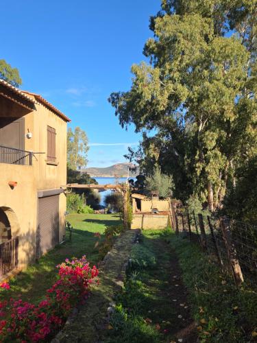 een tuin met een huis, een boom en bloemen bij Résidence Palmarella in Galeria
