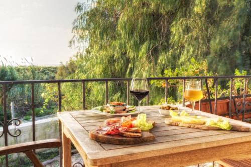 a wooden table with food and two glasses of wine at Agriturismo Vultaggio in Guarrato