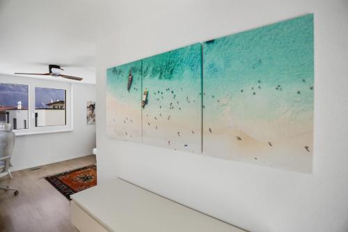 ein Wohnzimmer mit drei Gemälden an der Wand in der Unterkunft Saillon, maison 5 pers - Terrasse - Parking privé in Saillon