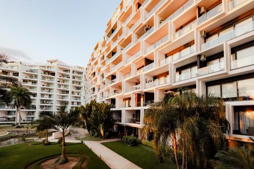 an apartment building with palm trees in front of it at Departamento moderno frente a playa Nuevo Vallarta in Nuevo Vallarta