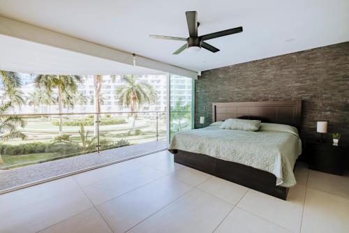 a bedroom with a bed and a large window at Departamento moderno frente a playa Nuevo Vallarta in Nuevo Vallarta