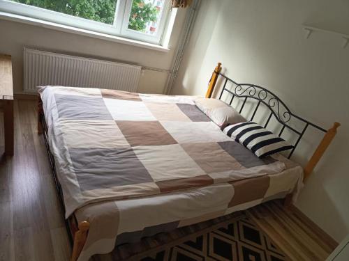 een bed in een slaapkamer met een geruite deken bij 2 in 4 Rooms Apartment in Tallinn