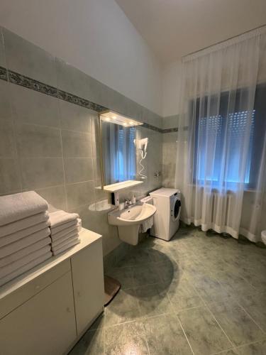 ein Badezimmer mit Waschbecken, Toilette und Spiegel in der Unterkunft La Grande Casa di Malpensa - casa vacanze in Gallarate