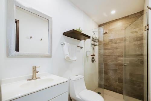 a bathroom with a toilet and a sink and a shower at Departamento moderno frente a playa Nuevo Vallarta in Nuevo Vallarta