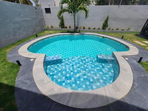 een zwembad met blauwe tegels in een achtertuin bij Villa Amani in Somone