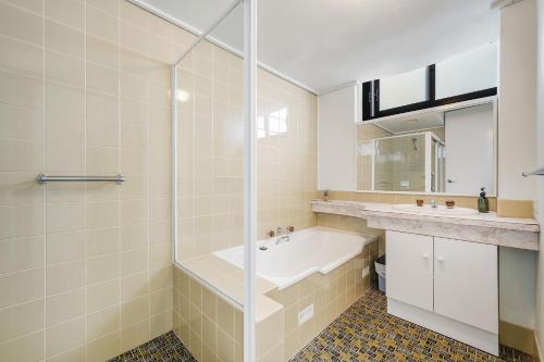 ein Badezimmer mit Badewanne, Waschbecken und Dusche in der Unterkunft Tasman Towers 12 3 Munster Street in Port Macquarie