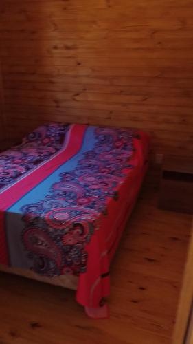 a bed sitting on top of a wooden floor at Cabaña Las Abuelas in Xuí