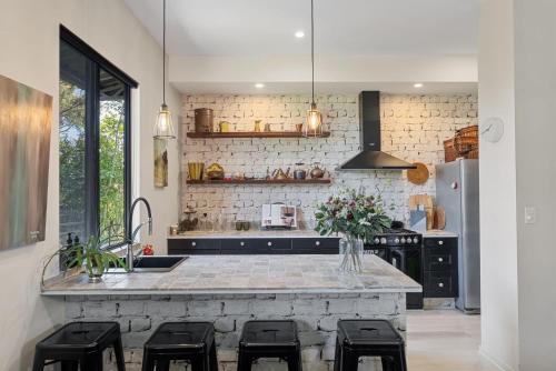 a kitchen with a counter with stools and a sink at Escape to a Mountain Retreat in Beechmont, Australia in Beechmont
