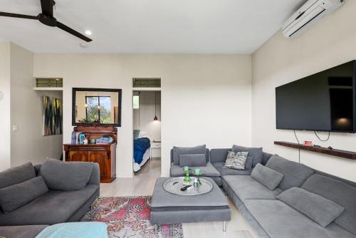 a living room with a couch and a flat screen tv at Escape to a Mountain Retreat in Beechmont, Australia in Beechmont