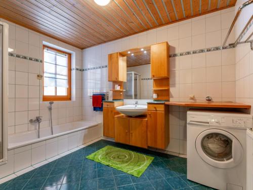een badkamer met wastafel en wasmachine bij Fintinn in Hüttschlag