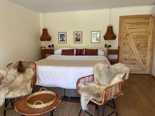 a bedroom with a bed with two chairs and a table at Uva Dulce B&B in Tunca Arriba