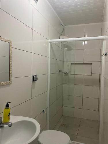 een badkamer met een douche, toilet en wastafel bij Casa a 3km da PRAIA Central in Guaratuba