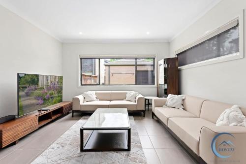 a living room with two couches and a tv at Cozy 4BR Family Haven Walk to Penrith CBD&Train in Penrith