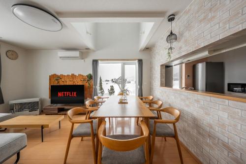 a living room with a table and chairs and a tv at Clematis in Nakafurano